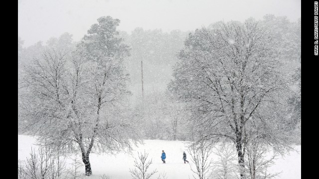People trek through a golf course in Durham, North Carolina, as heavy snow falls on Thursday, February 13.