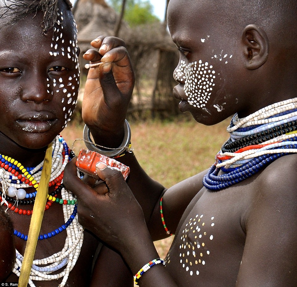 Taken at a Karo Village in the Omo Valley of Ethiopia. The Karo are famous for their body-paint culture and skill. Away from the crowded village square, I found this 'make up artist' focused on applying make-up on a young woman. Using a q-tip as a brush he used a Georges Seurat like Pointillism technique! The calm focused look of the artist is contrasted by the nervous, perspiring client - perhaps unsure about the results (or my camera :-)