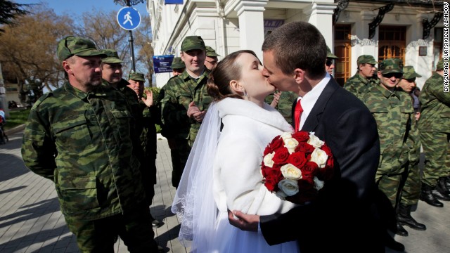 Members of a pro-Russian self-defense unit watch and applaud as a groom and a bride share a kiss at the central square of Sevastopol, Crimea, on Saturday, March 15. 