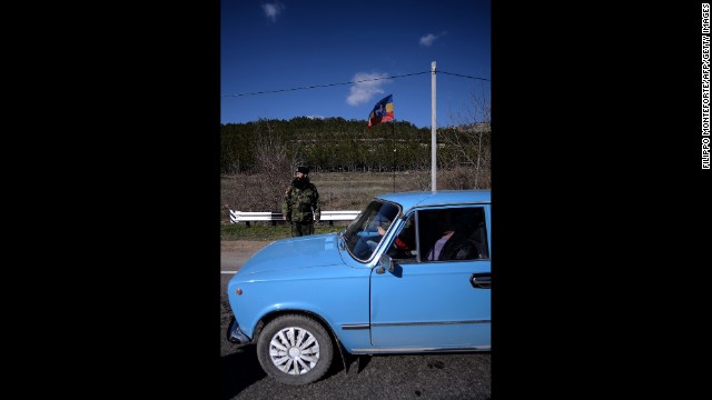 An armed Cossack stands guard at a checkpoint on the road from Simferopol to Sevastopol on March 13.