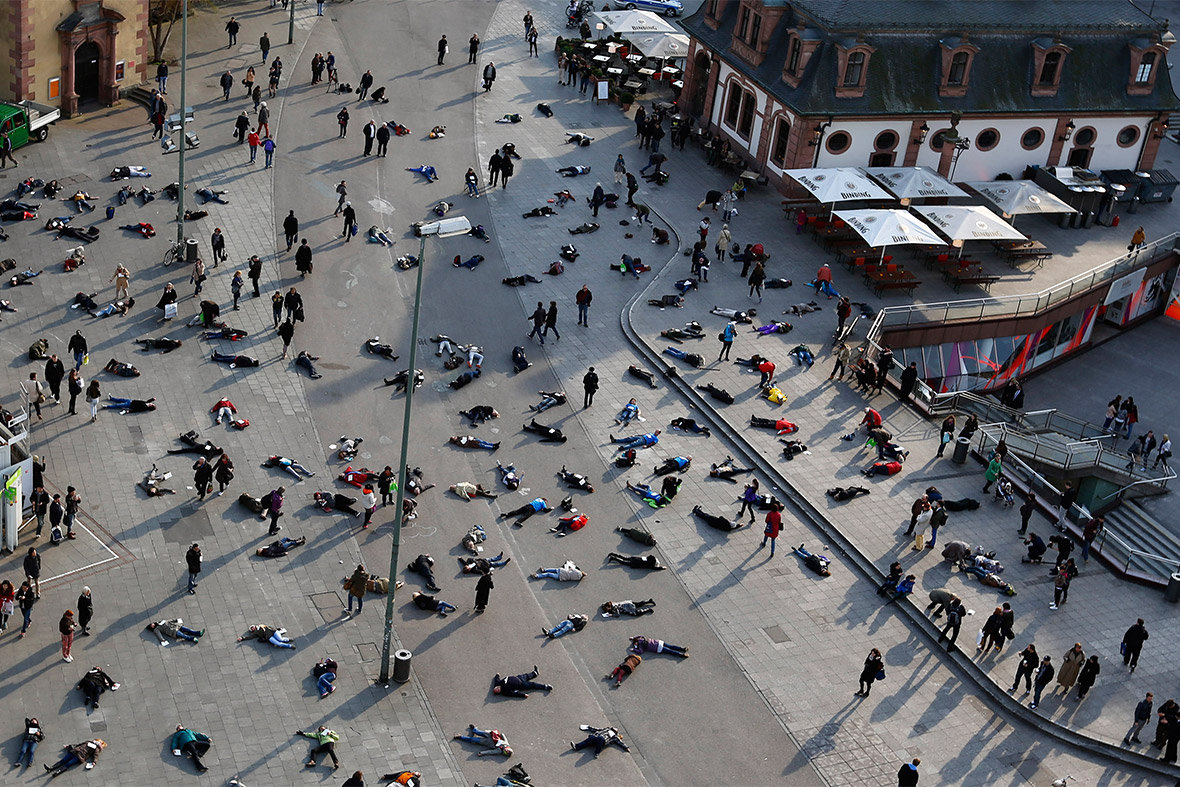 People lie down in a pedestrian zone in Frankfurt, as part of an art project in remembrance of 528 victims of the Katzbach Nazi concentration camp. The inmates of the Katzbach concentration camp, a part of the former Adler industrial factory, were forced into a death march to the concentration camps of Buchenwald and Dachau on March 24th 1945. Some 528 victims of Katzbach are buried at Frankfurt's central cemetery