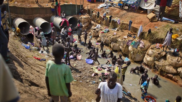Displaced people bathe and wash clothes in a stream in a U.N. compound in Juba on December 27.