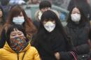Commuters wearing masks make their way amid thick haze in the morning in Beijing