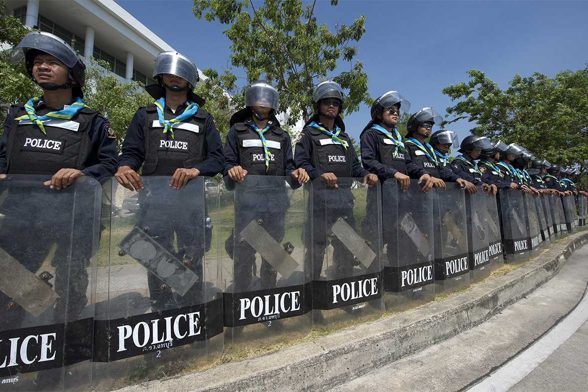 Thai riot police stand guard outside the National Anti-Corruption Commission in Nonthaburi province as Prime Minister Yingluck Shinawatra arrives to testify