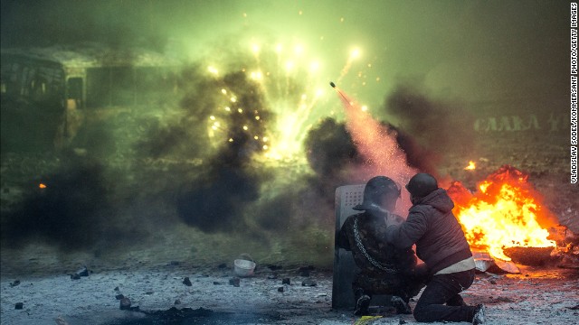 Protesters shoot from behind a shield among burning automobile tires in Kiev on January 22.