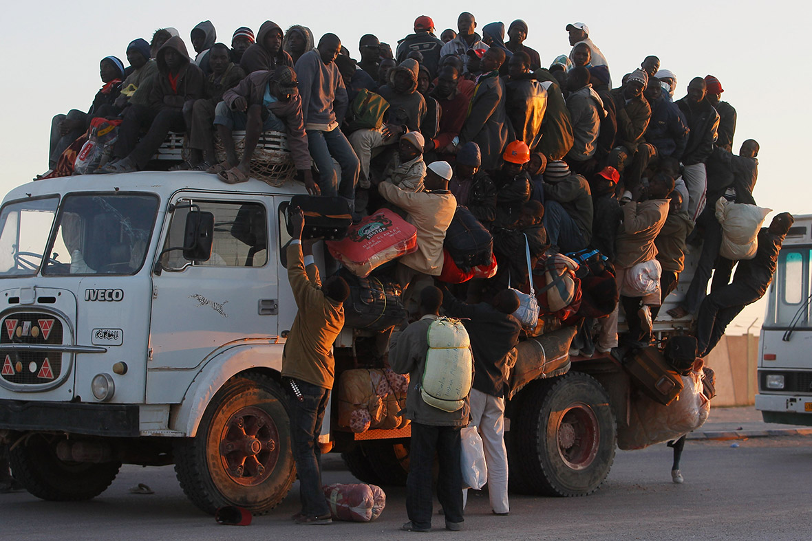 April 18, 2011: Foreign workers from Nigeria, Ghana, and other African countries pile onto the back of a truck with their belongings as they flee the besieged city of Misrata, Libya