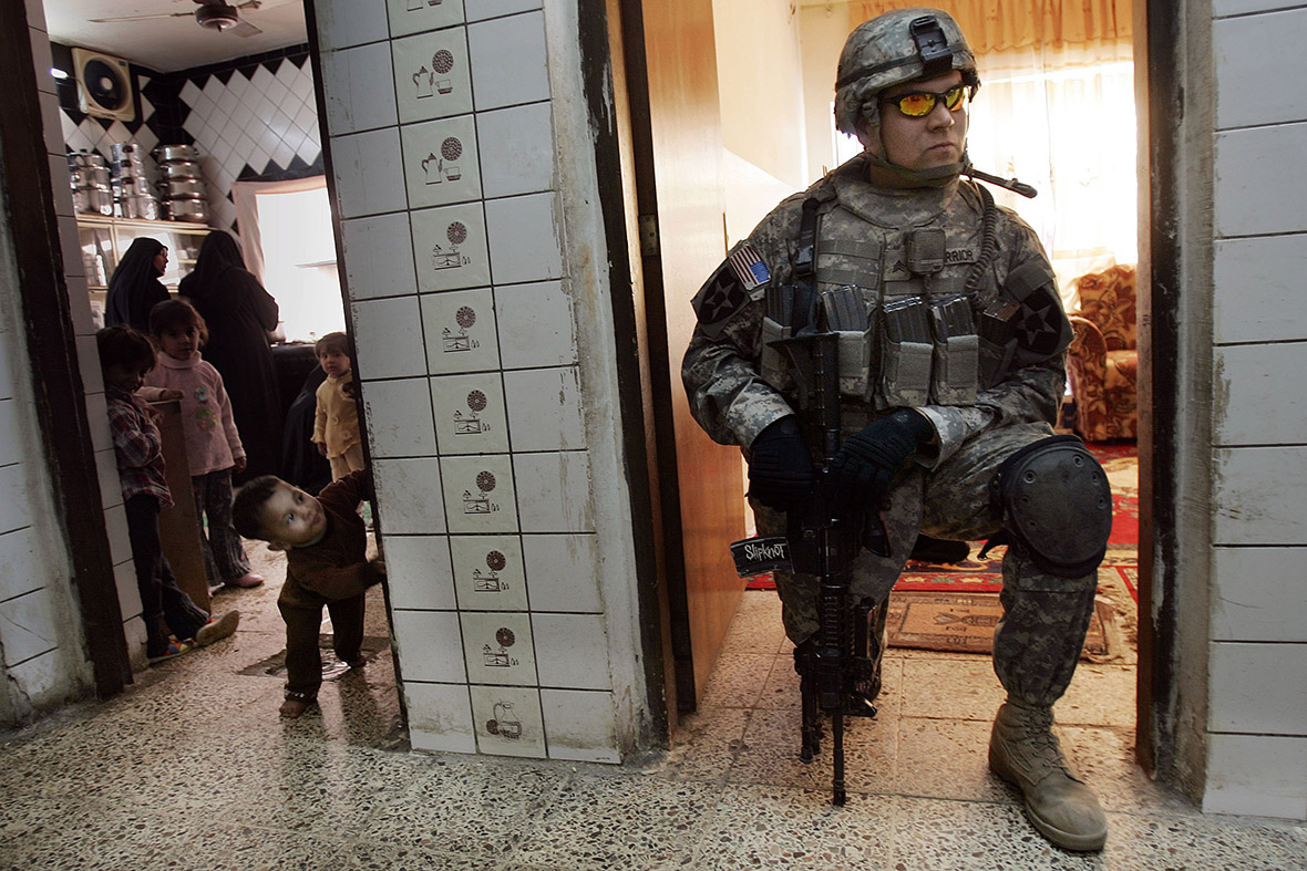 December 2, 2006: An Iraqi boy looks at Sgt Trevor Warrior of the US Army, during a search for weapons in the tense Shulah neighbourhood of Baghdad