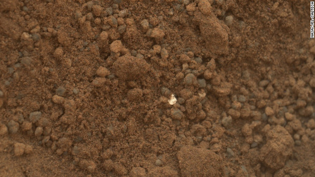 This image shows part of the small pit or bite created when NASA's Mars rover Curiosity collected its second scoop of Martian soil on October 15, 2012. The rover team determined that the bright particle near the center of the image was native to Mars, and not debris from the rover's landing.