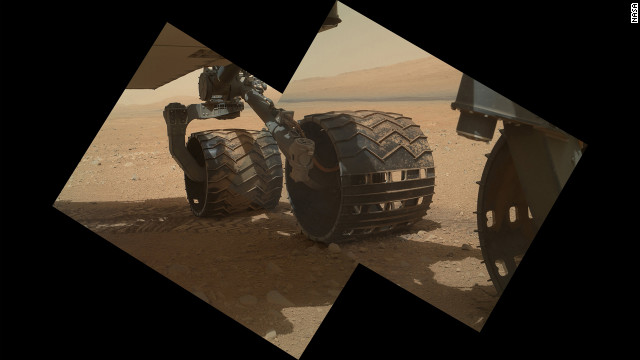 This view of the three left wheels of NASA's Mars rover Curiosity combines two images that were taken by the rover's Mars Hand Lens Imager on September 9, 2012, the 34th day of Curiosity's work on Mars. In the distance is the lower slope of Mount Sharp.