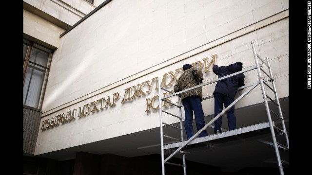 Nameplates on the front of the Crimean parliament building get removed Tuesday, March 18, in Simferopol after a controversial referendum to break away from Ukraine and join Russia. 
