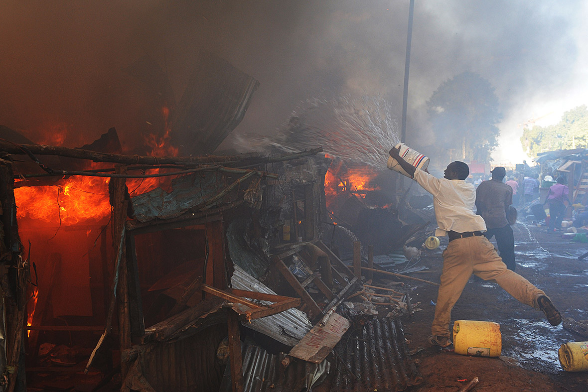 Kenyan men try to put out a fire caused by an electrical fault at the Deep Sea slum in Nairobi