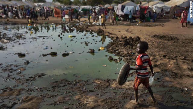A child plays with a tire next to a large puddle of muddy water inside the U.N. compound in Juba on December 29.