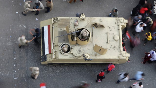 Egyptians walk around an armored personnel carrier parked at a pro-military rally in Tahrir Square. 