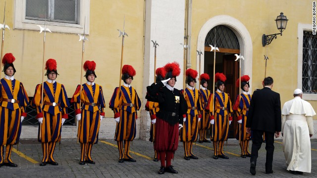Pope Francis walks past Swiss Guards after the meeting.