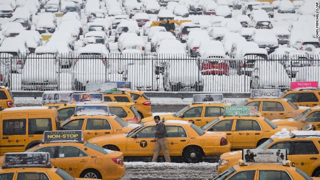 A taxi driver walks beside his vehicle in the parking lot of Terminal B at LaGuardia Airport on February 3.