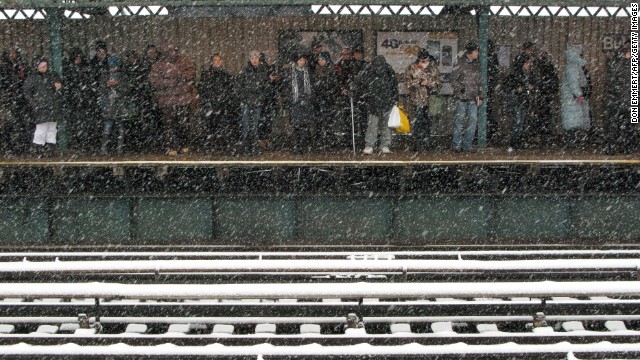 Commuters wait for a train as snow falls in New York on February 3.