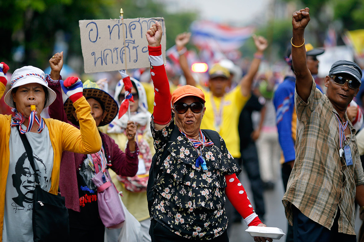 Anti-government protesters march in Bangkok after a Thai court found Prime Minister Yingluck Shinawatra guilty of violating the constitution and said she had to step down.