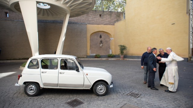 Francis has eschewed fancy cars. Here, Father Don Renzo Zocca, second from right, offers his white Renault 4L to the Pope during a meeting September 7 at the Vatican. 