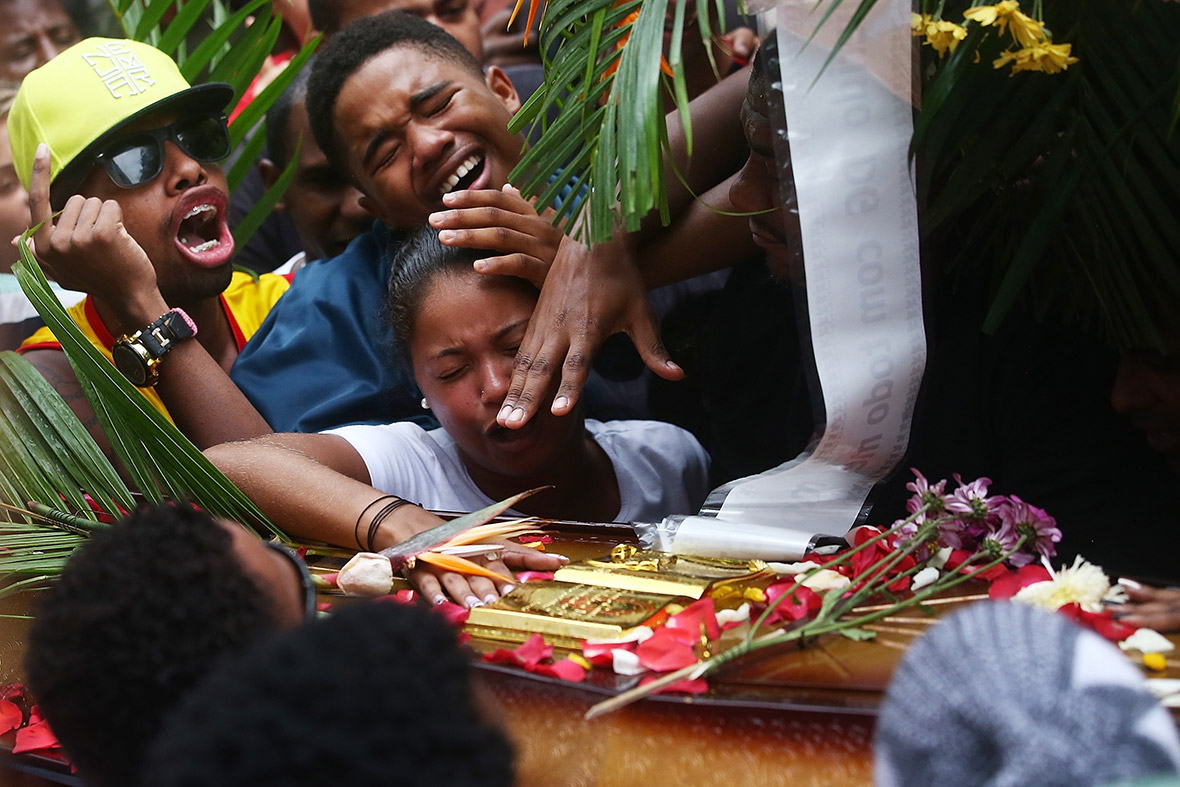 People mourn over the coffin of dancer Douglas Rafael da Silva, whose body was discovered in the Pavao-Pavaozinho slum, just blocks from Rio's Copacabana Beach. Protests and shootings broke out as a result after protesters alleged he was killed by police