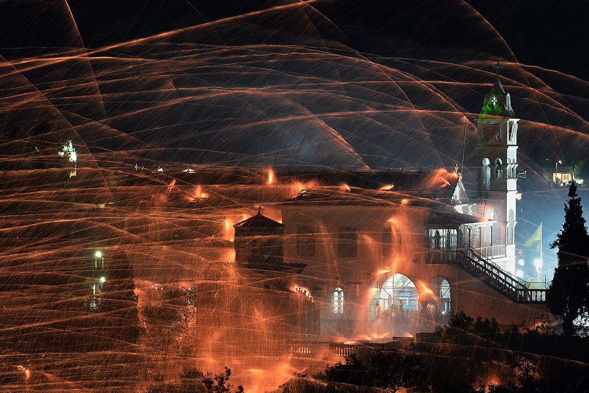 Homemade rockets streak through the sky during a traditional Easter celebration in the village of Vrontados, on the Greek island of Chios