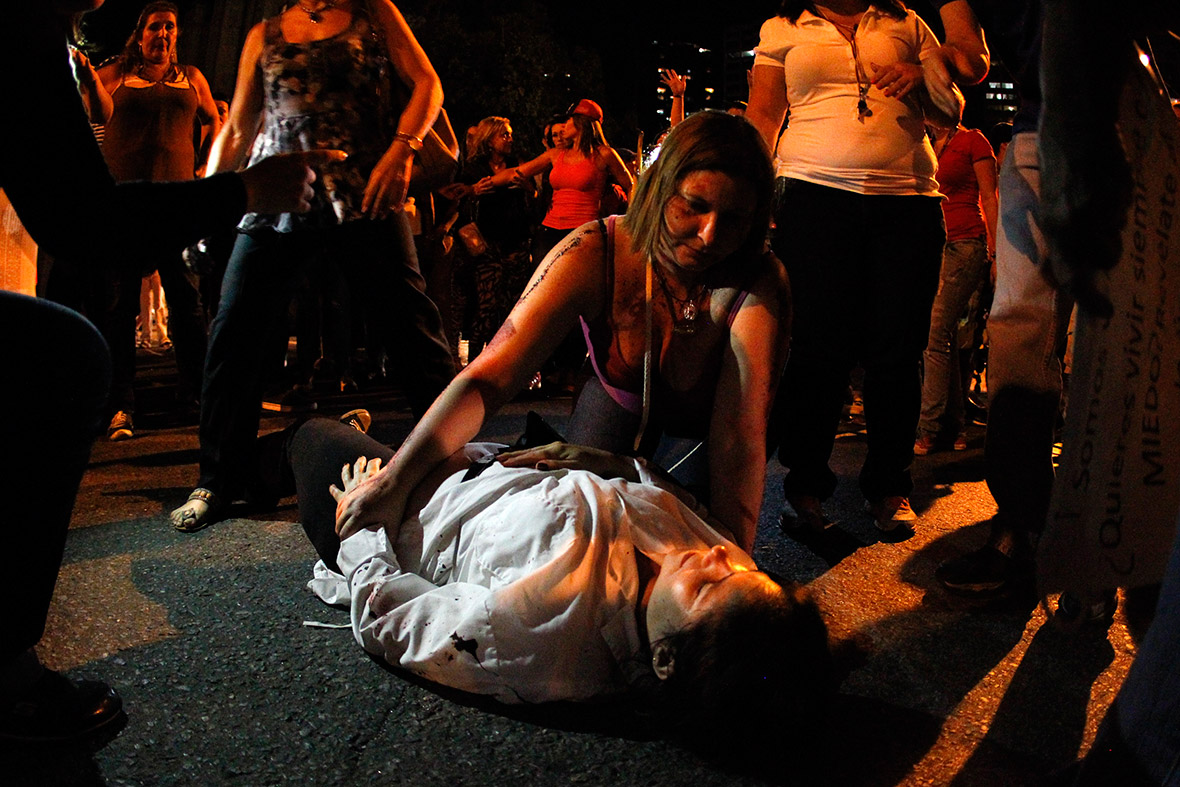 Protester Isabel Loaiza lies on the ground after being hit by an SUV during an anti-government protest in El Cafetal in Caracas
