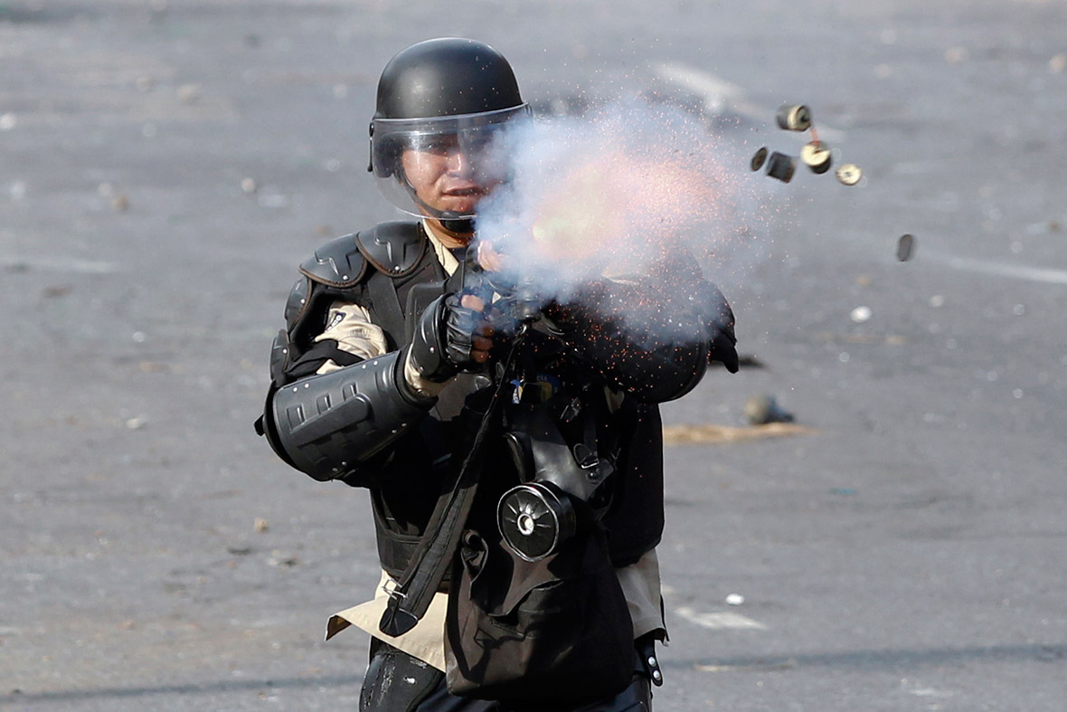 A member of the national police fires tear gas towards anti-government protesters