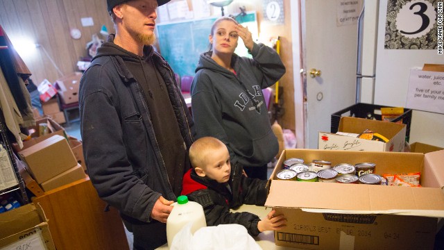 C.J. and Michelle Anderson, along with their 4-year-old son Cameron, pick up food from the Darrington Food Bank on Friday, March 28, at the First Baptist Church in Darrington. C.J.'s commute to the chicken farm where he works has gone from three minutes to three hours because of the closure of State Route 530, cutting down time with family and hurting them financially with increased fuel costs. 