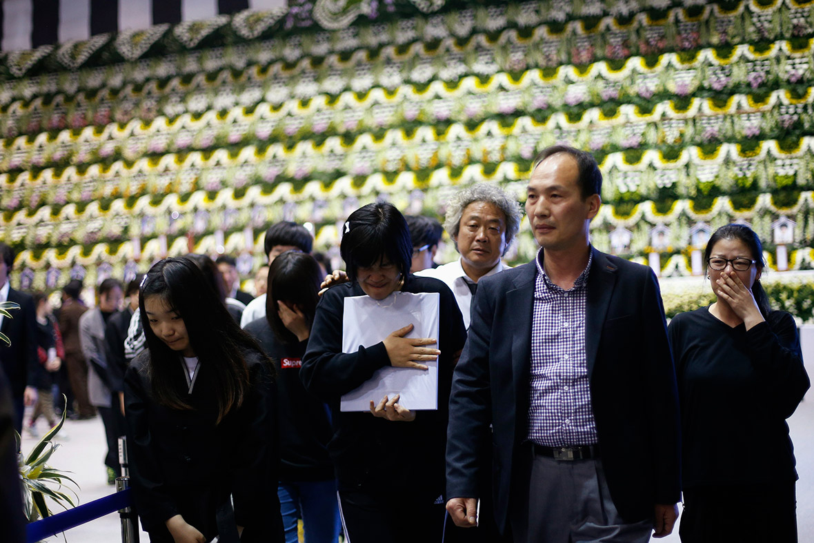 A woman holding a portrait cries after paying tribute at the group memorial altar in Ansan