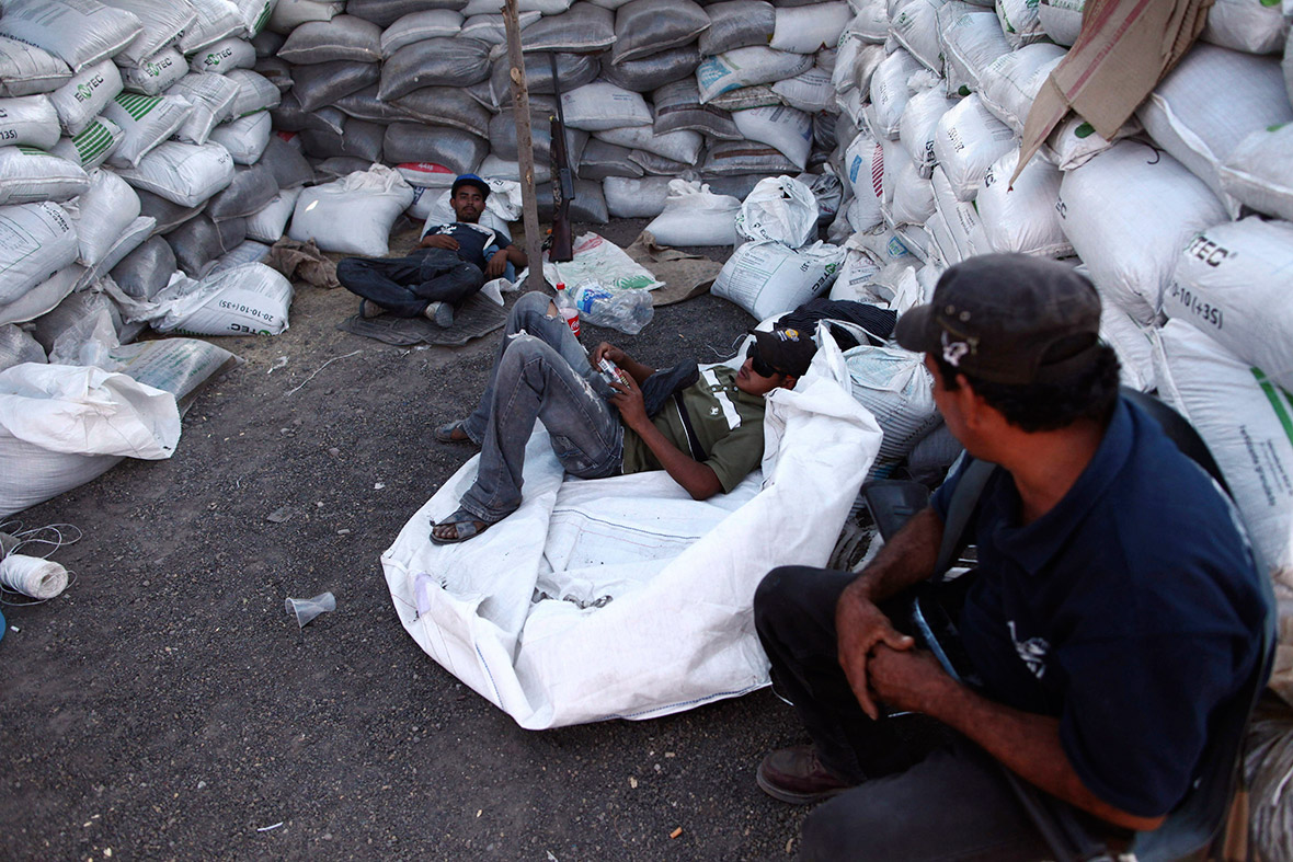 Vigilantes rest inside a barricade on the outskirts of Apatzingan, in Michoacan state