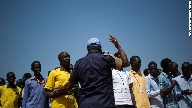 A United Nations peacekeeper gestures as South Sudanese students wait to walk back to a camp for internally displaced people after taking an English exam at a United Nations base in Juba on Monday, January 13.