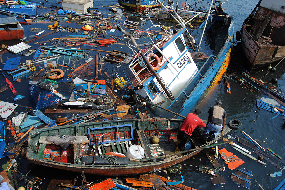 Fishermen try to salvage their boats in the port of Iquique