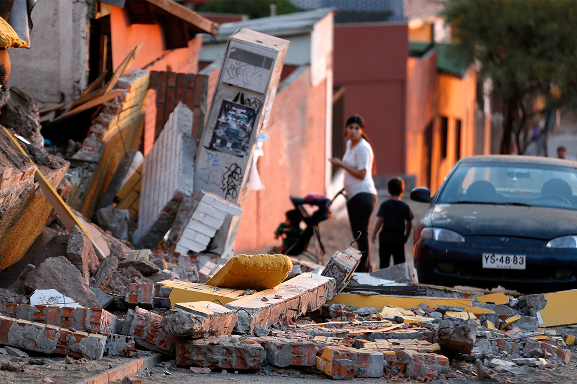 A resident looks at debris around a home caused by Tuesday evening's earthquake