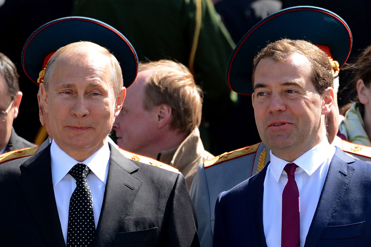 Russian President Vladimir Putin and Prime Minister Dmitry Medvedev appear to wearing army uniform hats as they stand in front of members of the military during a wreath-laying ceremony at the Tomb of the Unknown Soldier outside the Kremlin in Moscow.