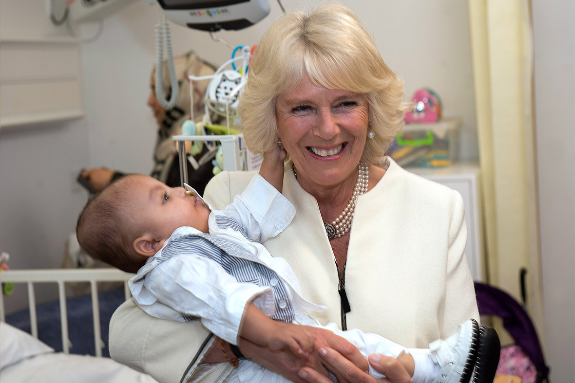 Ten-month old Maijed Dhaif grabs hold of one of Camilla's earrings as the Prince of Wales and Duchess of Cornwall officially open the new Chelsea and Westminster Children's Hospital in London