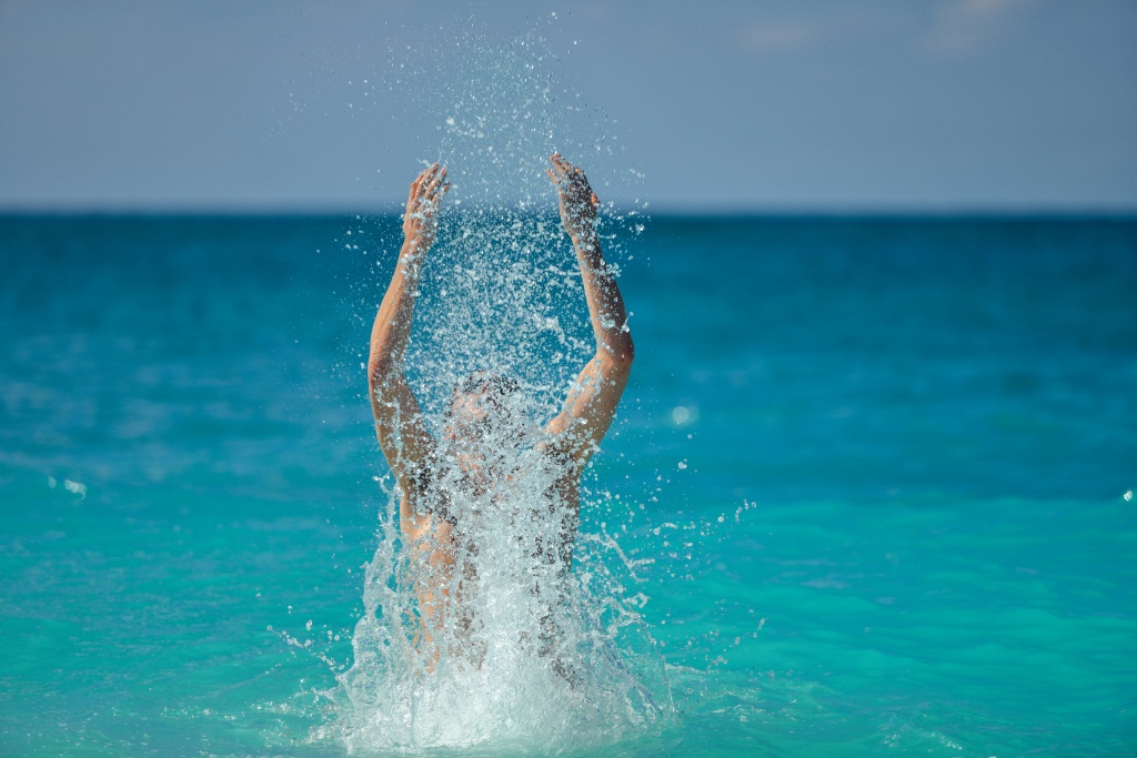 Happy Man Splashing Water In The Ocean