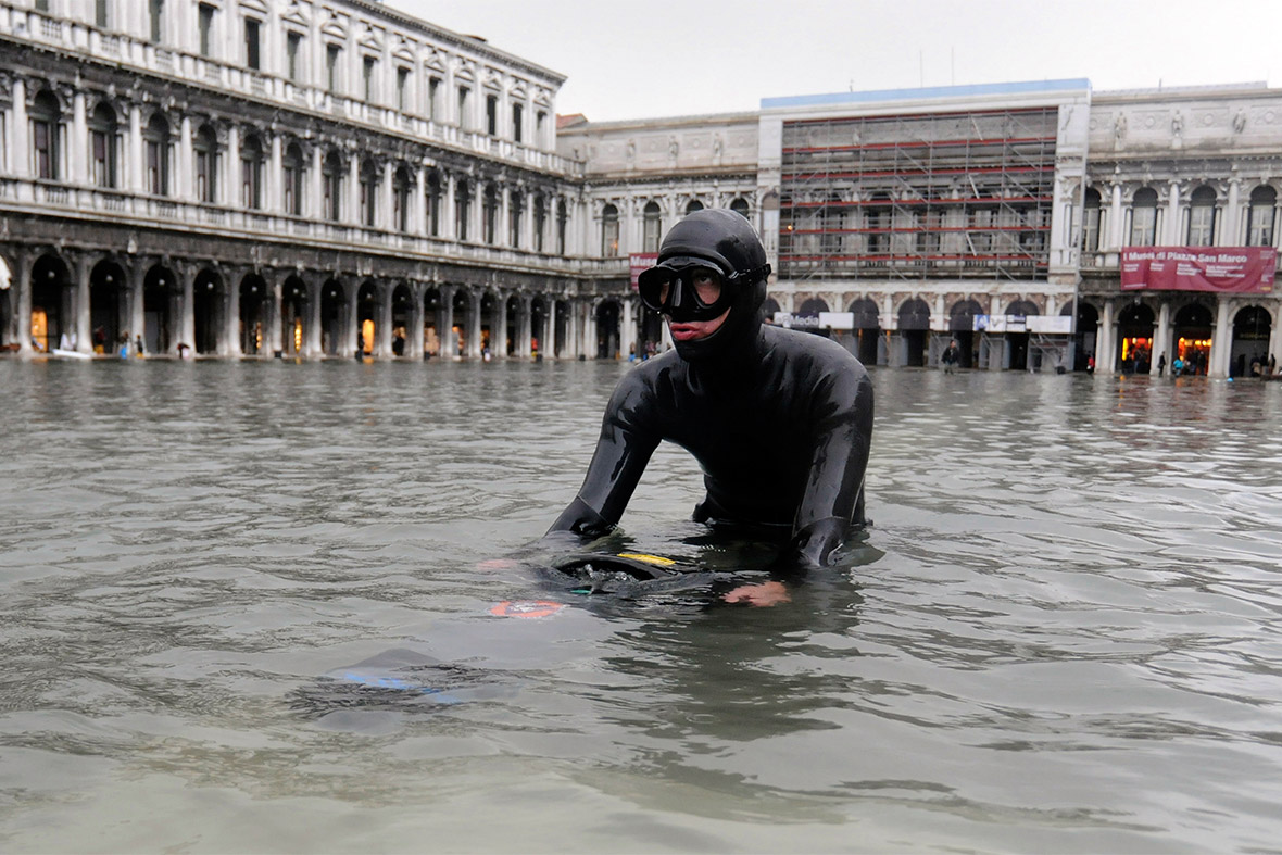 A man in scuba diving gear wades through floodwaters in Saint Mark's Square in Venice on December 3, 2010. Rising sea levels could threaten the city's existence
