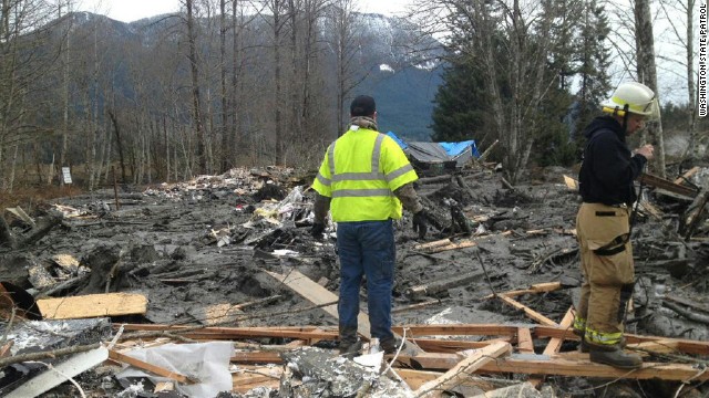 Emergency workers arrive at the scene of the landslide on Saturday, March 22.
