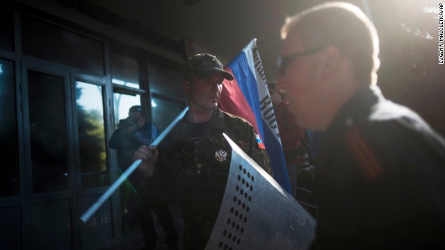 A pro-Russian activist stands with a Russian national flag outside the regional Interior Ministry building in Luhansk, Ukraine, on Wednesday, May 7.