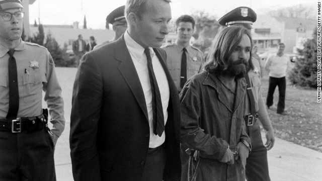 Cult leader Charles Manson is taken into court to face murder charges on December 5, 1969, in Los Angeles. At Manson's command, a small group of his most ardent followers brutally murdered five people at the Los Angeles home of film director Roman Polanski on August 8-9, 1969, including Polanski's pregnant wife, actress Sharon Tate. Manson was convicted for orchestrating the murders and sentenced to death. The sentence was later commuted to life in prison.