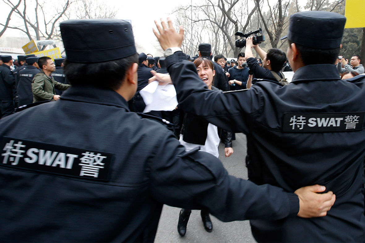 Police attempt to prevent relatives from marching towards the Malaysian Embassy in Beijing