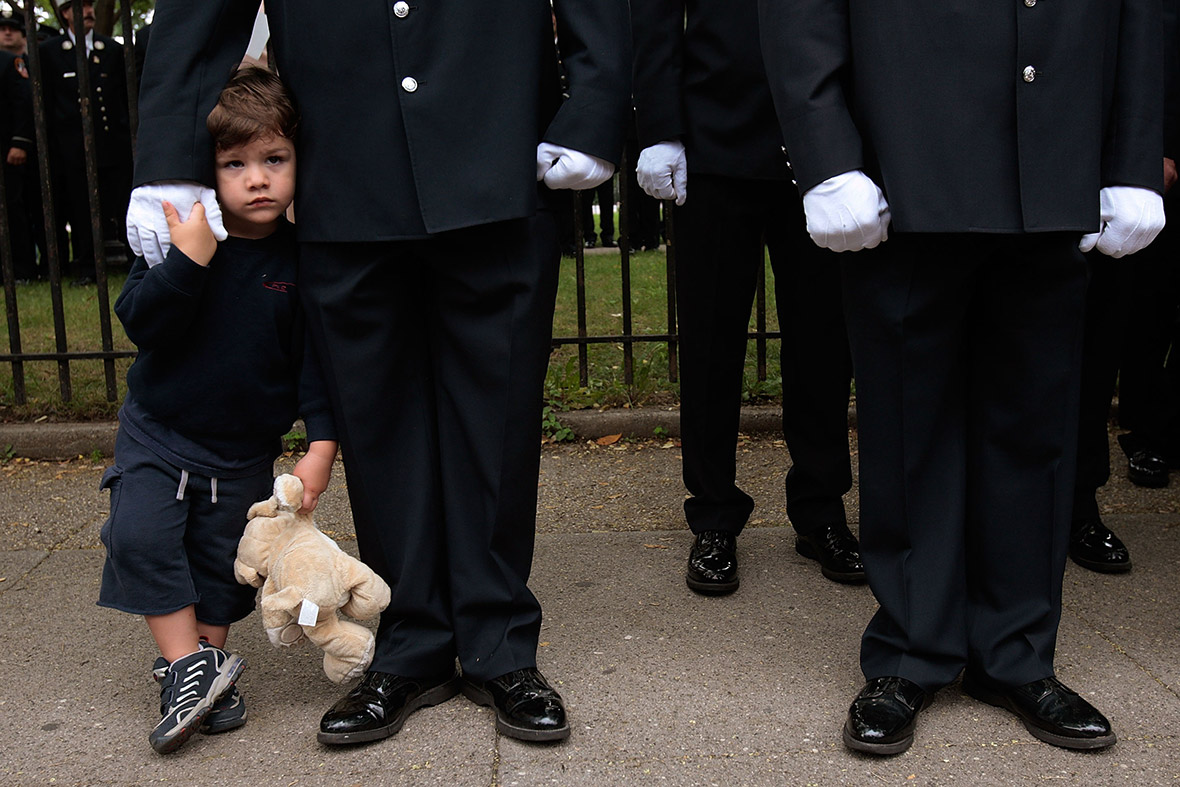 August 23, 2007: Michael Patrick Shepherd, 3, stands next to his father, Mike Shepherd, during the funeral for his fellow New York firefighter Joseph Graffagnino in Brooklyn, New York City