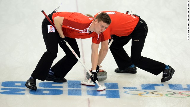 Denmark's Troels Harry, left, and Mikkel Poulsen sweep in front of a curling stone during a match against Russia on February 10.