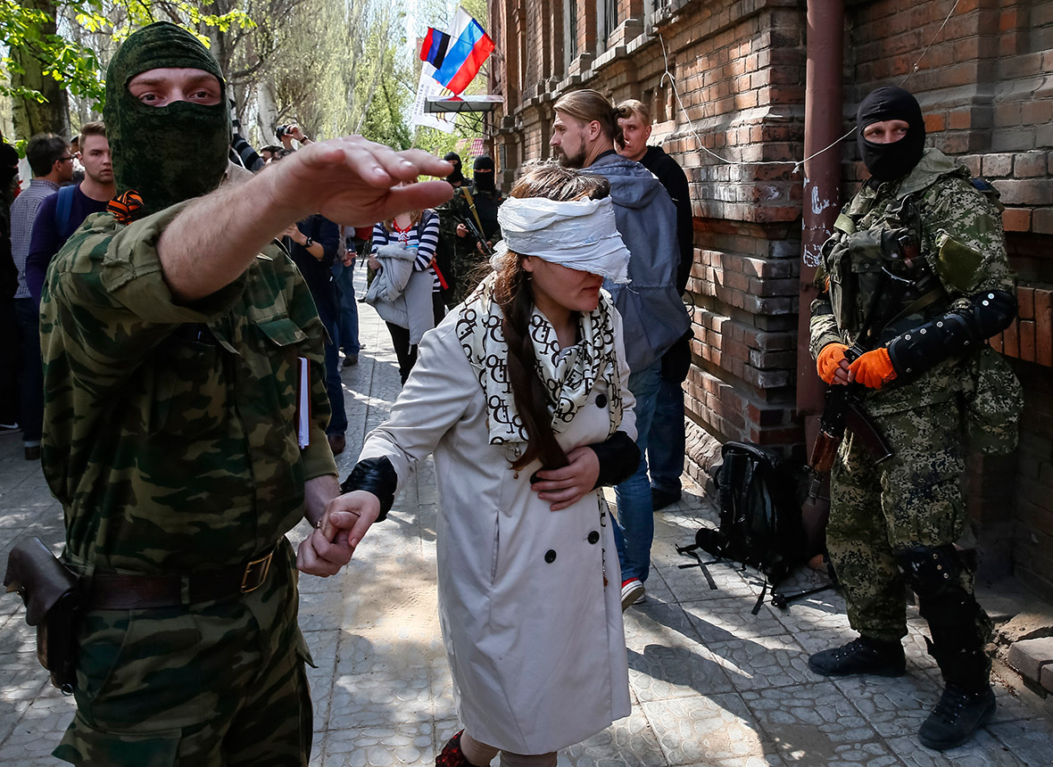 A pro-Russian armed man escorts Ukrainian journalist Irma Krat after a news conference in Slaviansk. Pro-Russian separatists detained the journalist, accusing her of 
