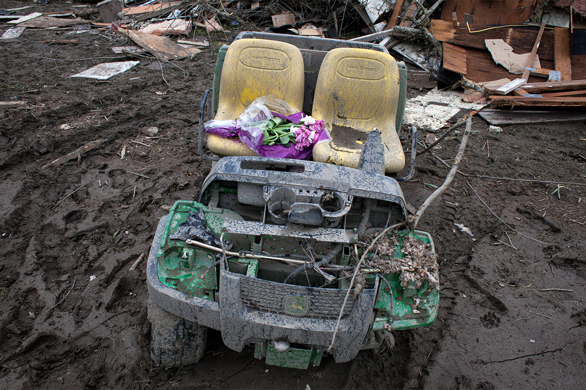 A bouquet of flowers lies on a damaged farming vehicle in the aftermath of a mudslide in Oso, Washington State
