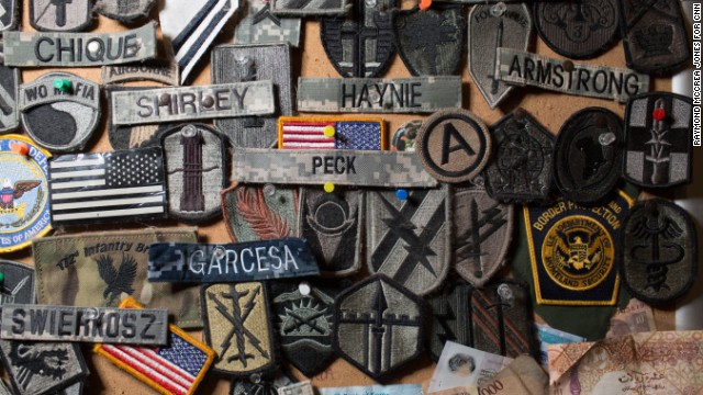 A corkboard full of military patches and souvenirs is mounted to the wall of a Starbucks near a security checkpoint. Employees say troops who come through the airport offer the patches as a way of saying thanks, since the coffee shop won't let them pay.