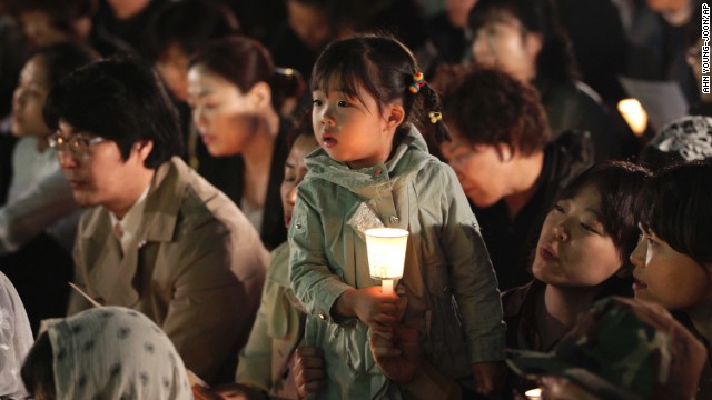 A girl in Seoul, South Korea, holds a candle during a service paying tribute to the victims of the sunken ferry Sewol on Wednesday, April 30. 