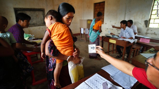 An official checks a voter's identity card in Agartala, India, on Monday, April 7.