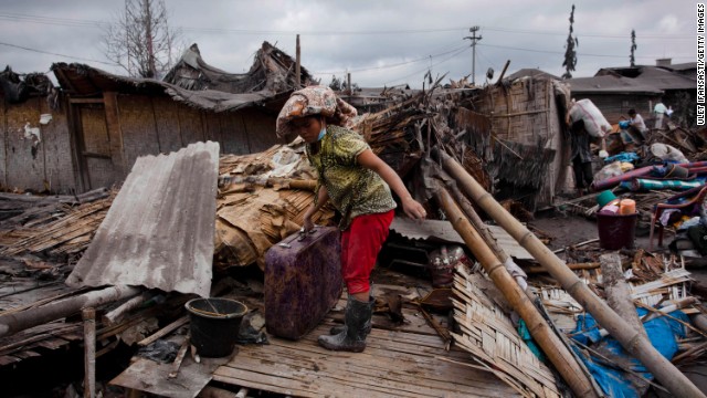 A villager looks for belongings among debris at a house damaged by ash and mud from eruptions of Mount Sinabung on January 12.
