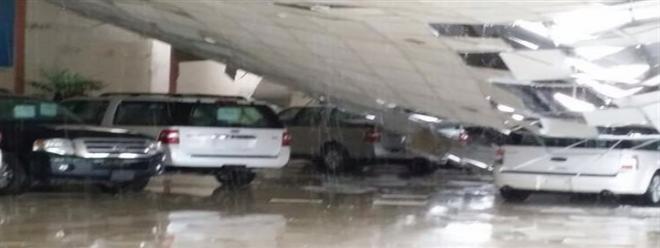 صور : الأمطار الغزيرة تتسبب بانهيار سقف صالة سيارات فى السعودية