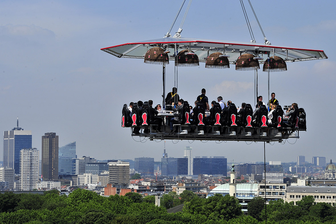 Diners eat suspended in the air above the Parc du Cinquantenaire in Brussels